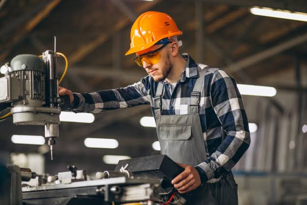 Técnico industrial operando máquina convencional em chão de fábrica